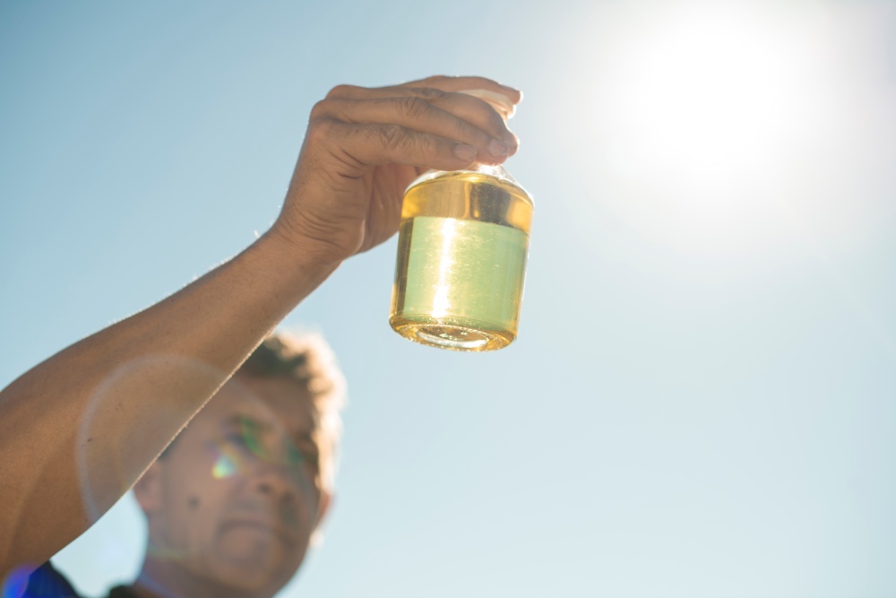 man holding a bottle of manuka oil under the sun