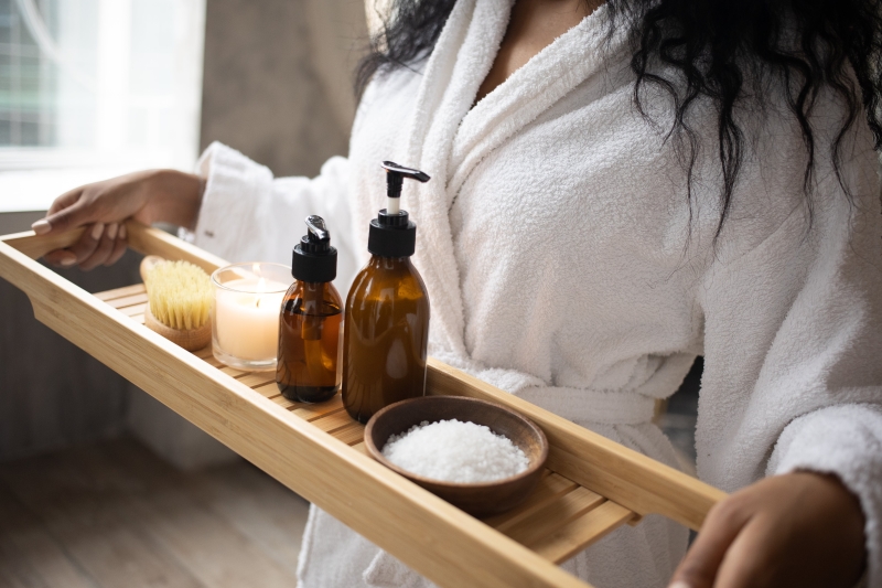 Crop black woman with tray of spa products and manuka essential oil The Wonders of Mānuka Oil: A Guide to Health, Skin, and Hair Care www.manukaoil.com