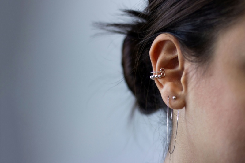silver-coloured piercings on ear